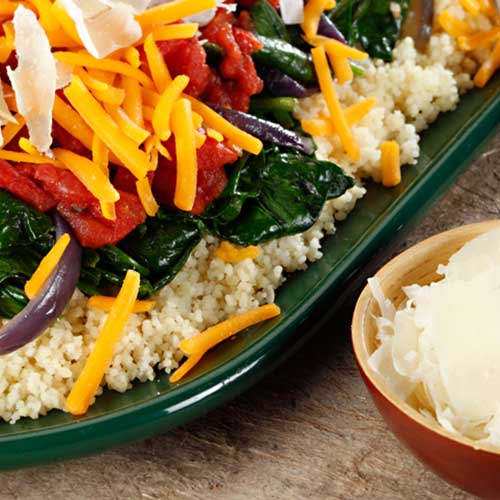couscous piled high with sauteed spinach, tomatoes and cheese