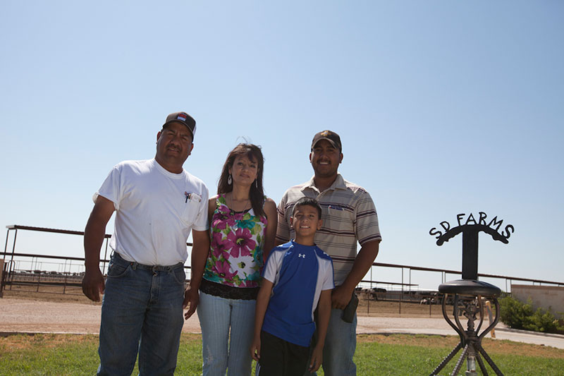 The Vasquez family poses with the SD Farms sign.