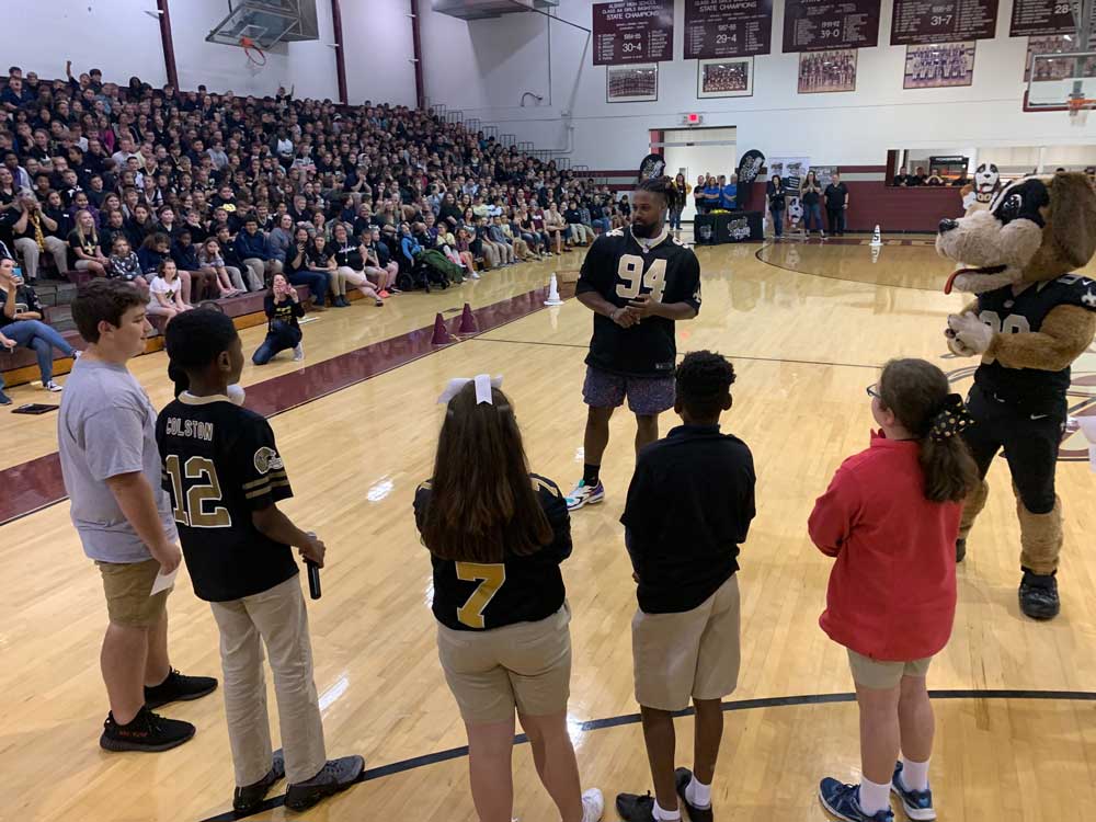 Cam Jordan speaks with a group of students
