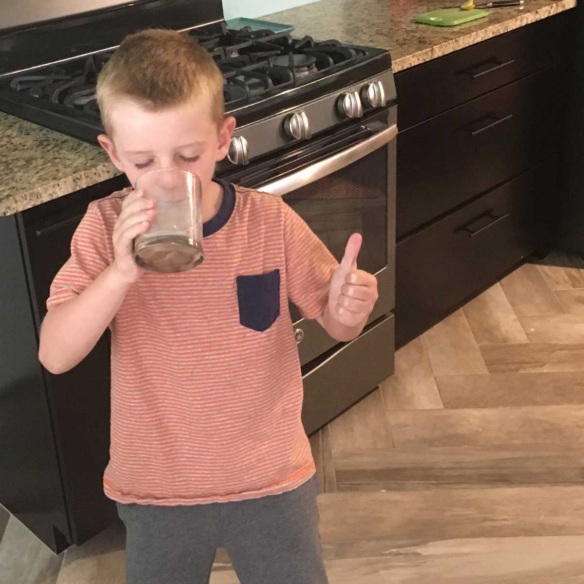kid drinking milk and giving a thumbs up