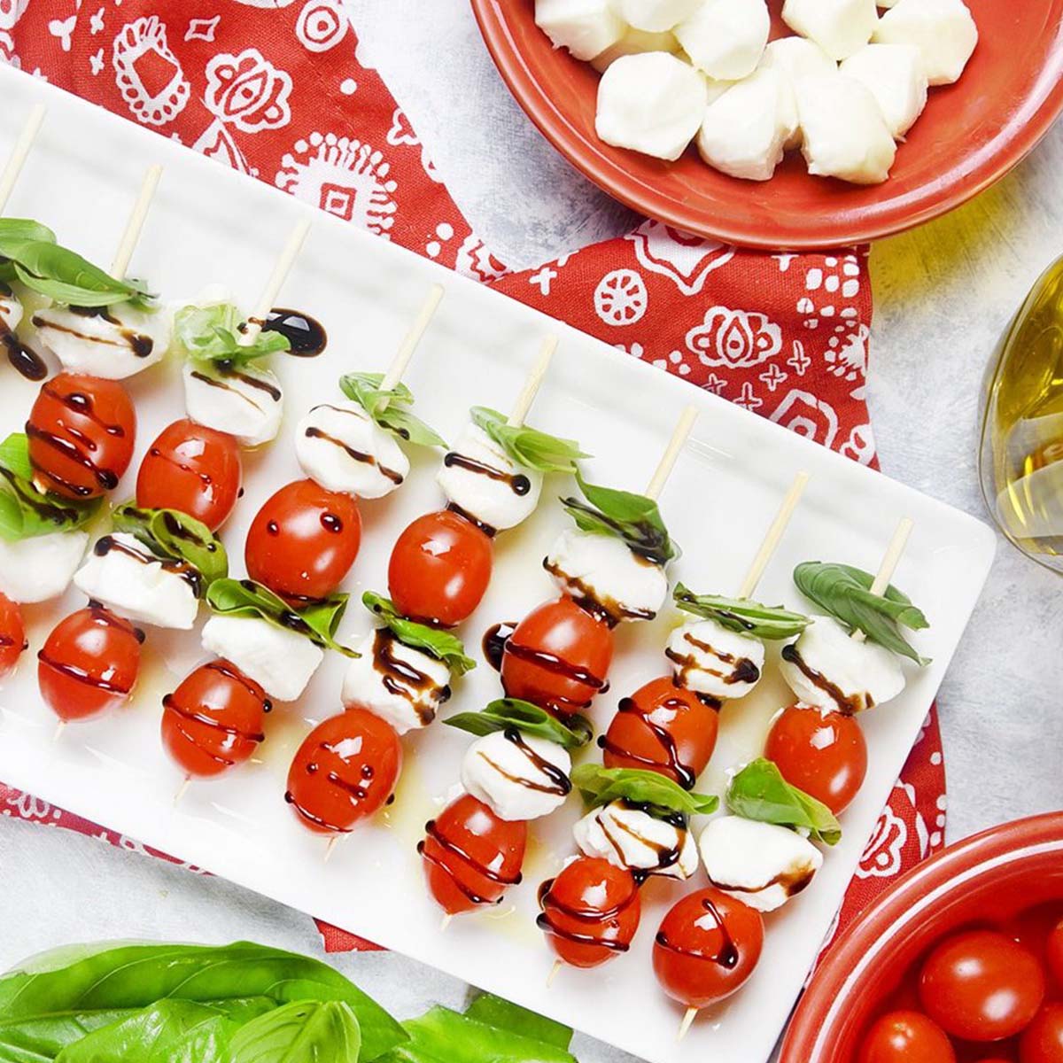 caprese skewers lined up on a plate