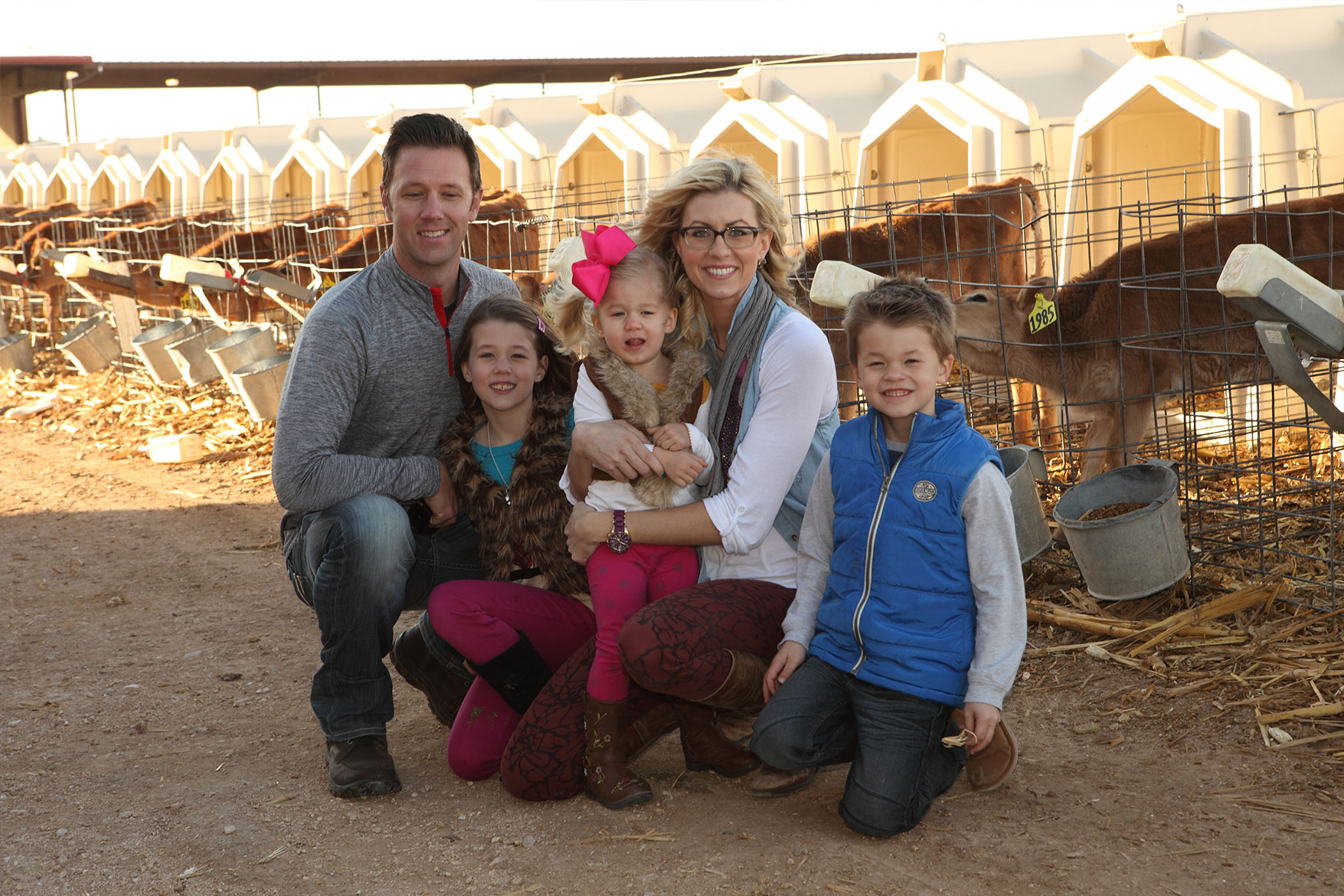 The Ballou family poses in front of their calves.