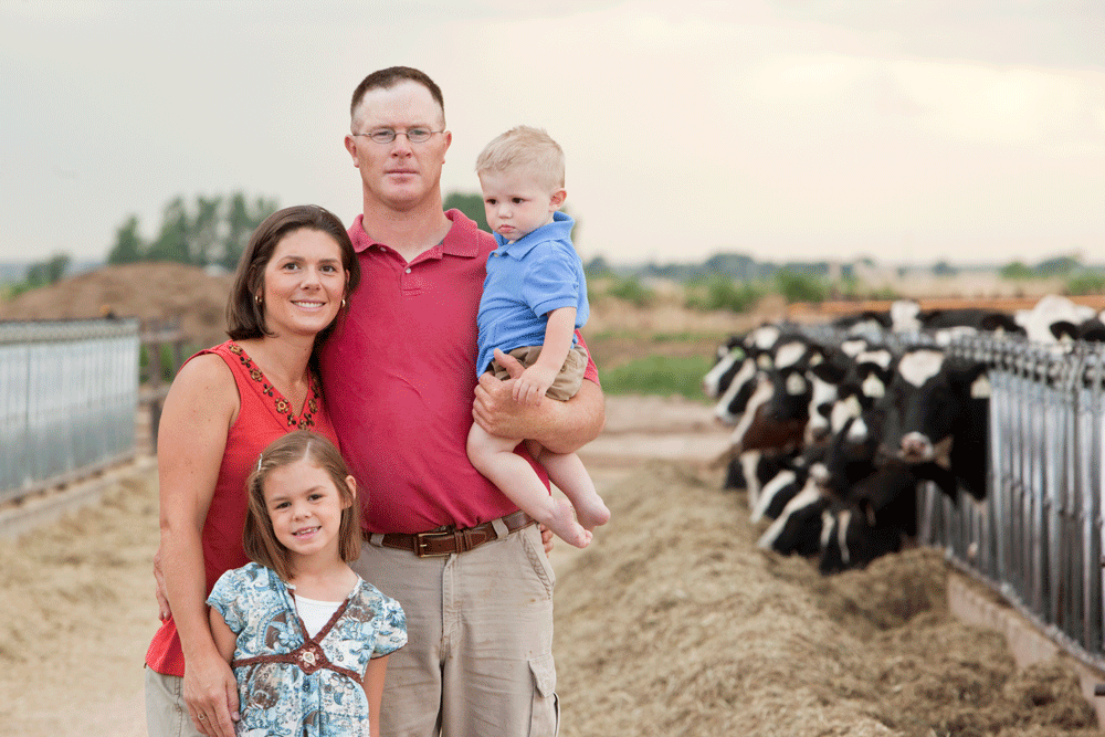 The Edstrom family poses in front of their dairy cows.