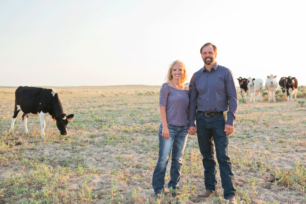 Dennis and Jennifer pose with some of their Holsteins in a field.