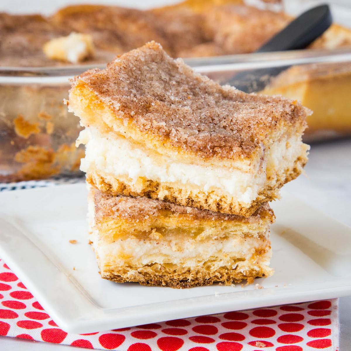 cheesecake bars stacked on a white plate