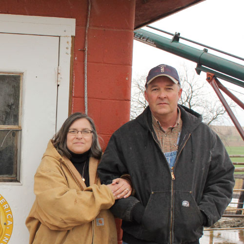 husband and wife dairy farmers near the milking parlor