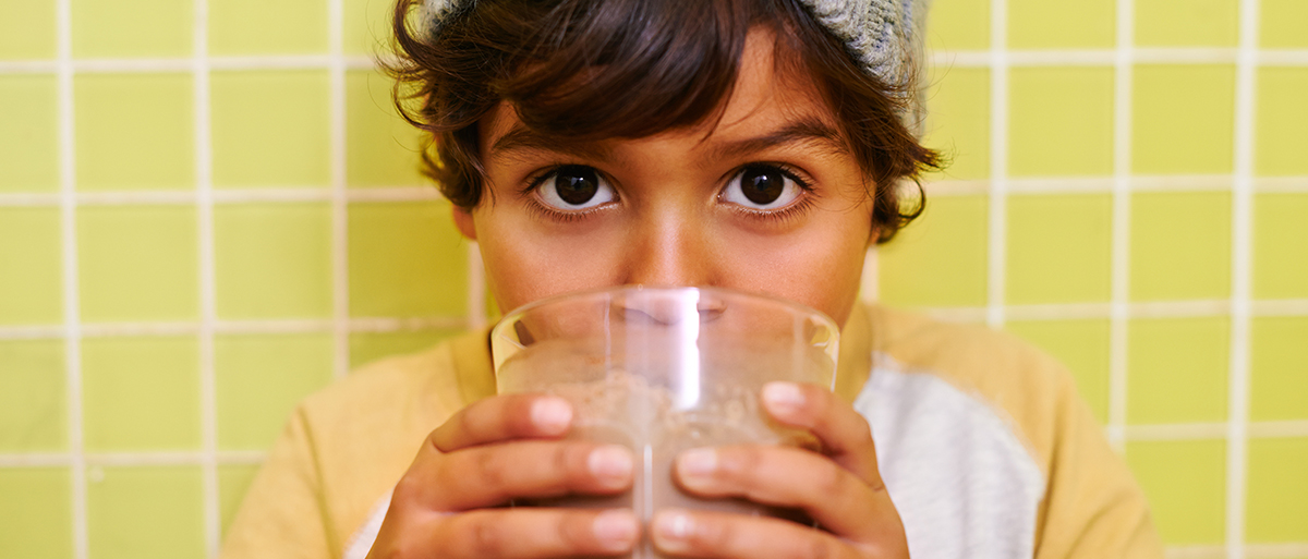 child drinkign a glass of milk