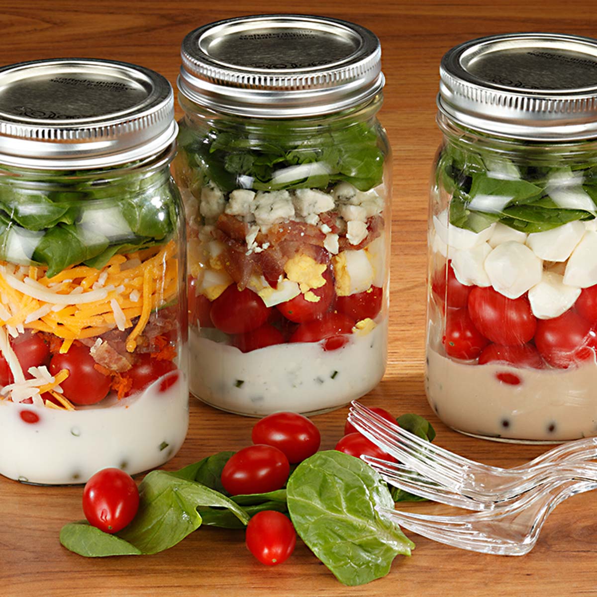 three mason jars full of layered salad