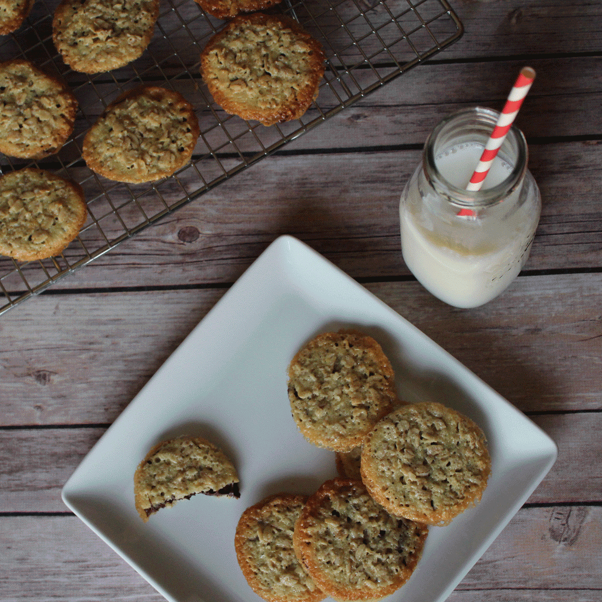 oat and chocolate lace sandwich cookies with a glass of milk