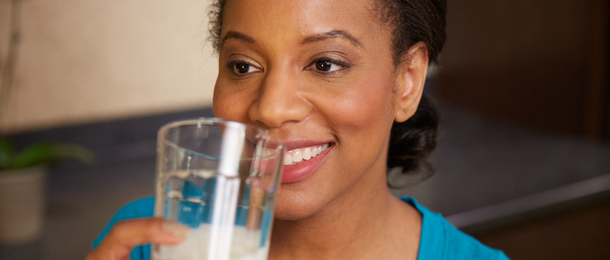 woman drinking a glass of milk and smiling